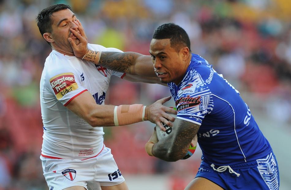 Tim Simona of Samoa fends off the tackle by Matty Smith of England during the Four Nations match...