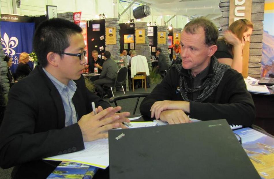 V-Tour Zhejiang Travel Service delegate Mike Shao (left), who lives near Shanghai, discusses...