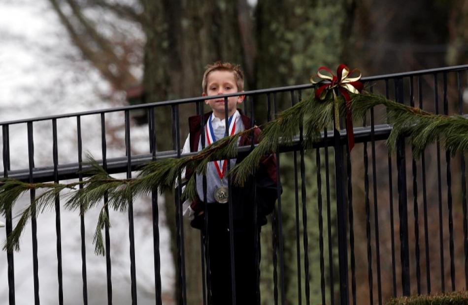 A boy waits to enter the funeral home where the family of six-year-old Jack Pinto, a victim of...