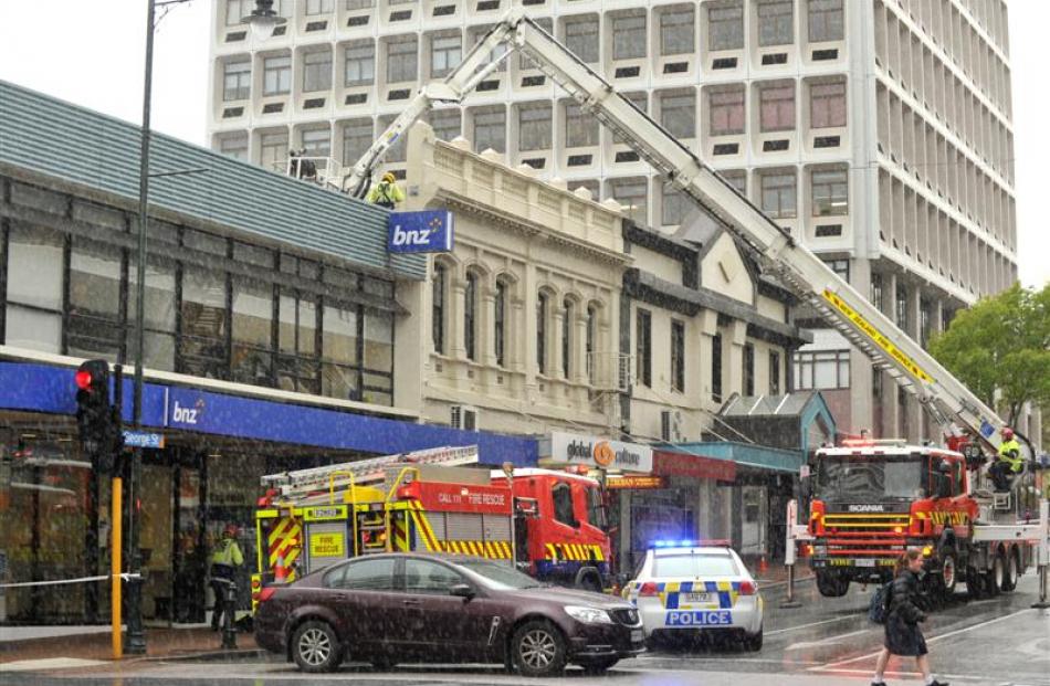 A cable running from  a George St  building across the street is taken down after a crack was...