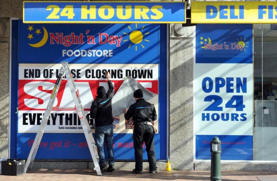 A closing down sale sign is put up at Night'n Day on the corner of George St and St Andrew St....