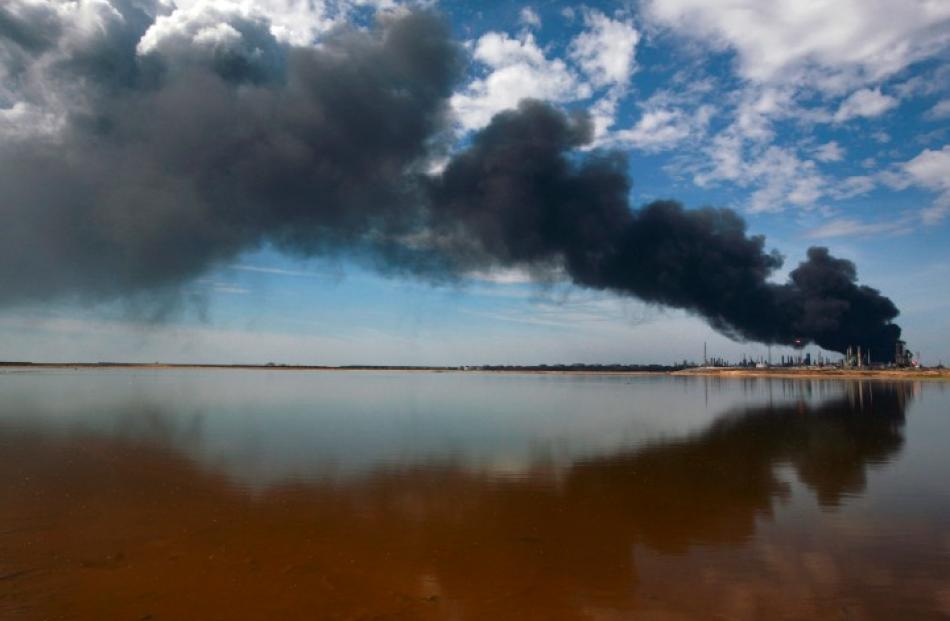 A column of smoke rises from a fire at Amuay oil refinery in Punto Fijo in the Peninsula of...
