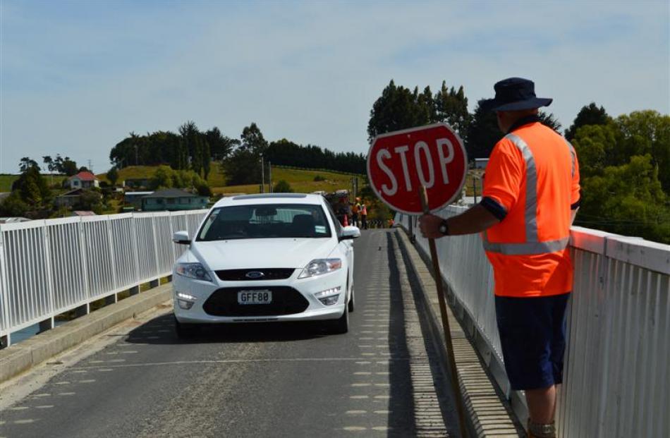 A contractor controls traffic on the Clydevale bridge  as  preparations are made to  repair the...