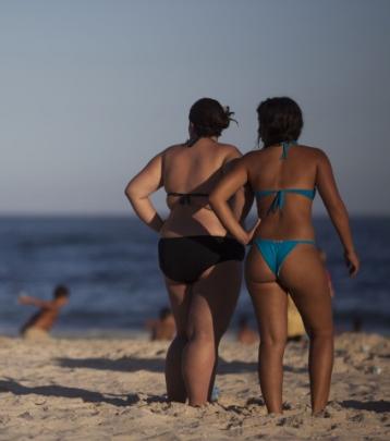 A couple of women look out at the water at Copacabana beach in Rio de Janeiro, Brazil.  (AP...