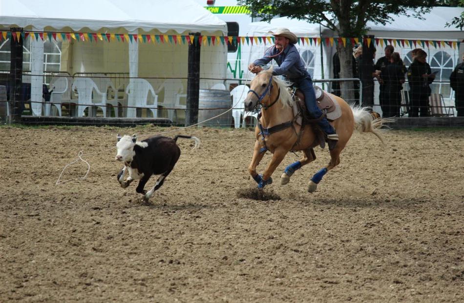 A cowboy attempts to lasso in and catch a calf at the Lawrence Rodeo on Saturday. Photos: Samuel...