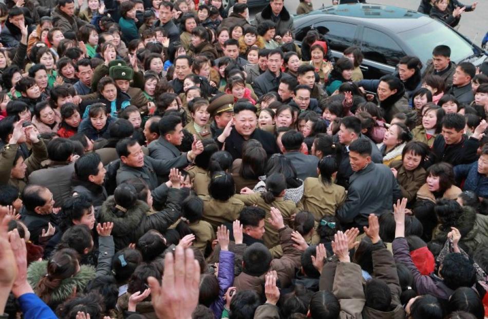A crowd surrounds North Korean leader Kim Jong Un (C) while he gives field guidance at the Kim...