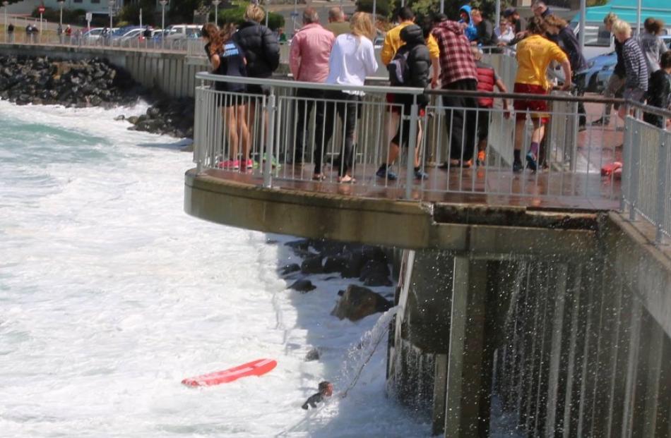 A crowd watches the surfer struggling in the water. Photos Barbar Newton