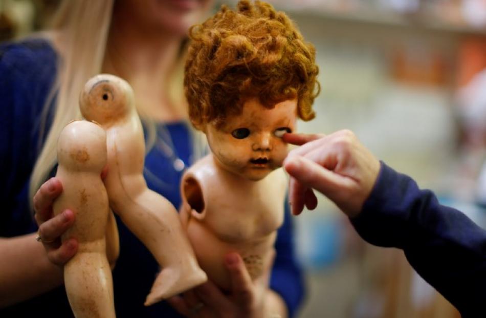 A damaged doll is brought in for repair by a customer at Sydney's Doll Hospital. Photos: REUTERS...