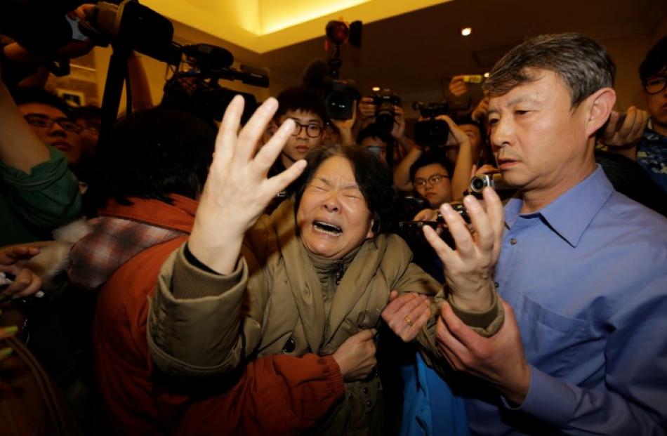 A family member of a passenger reacts after hearing the news that there were no survivors, at the...