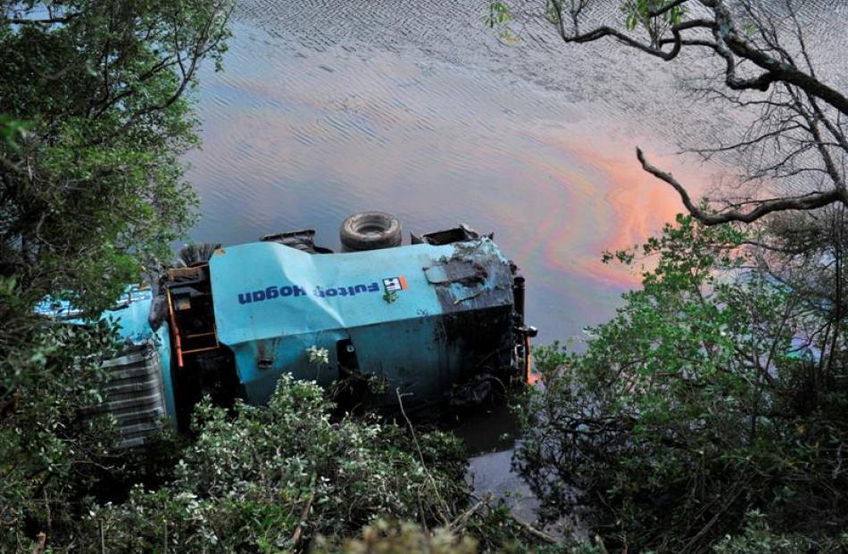 A Fulton Hogan truck lies in Otokia Creek  yesterday.