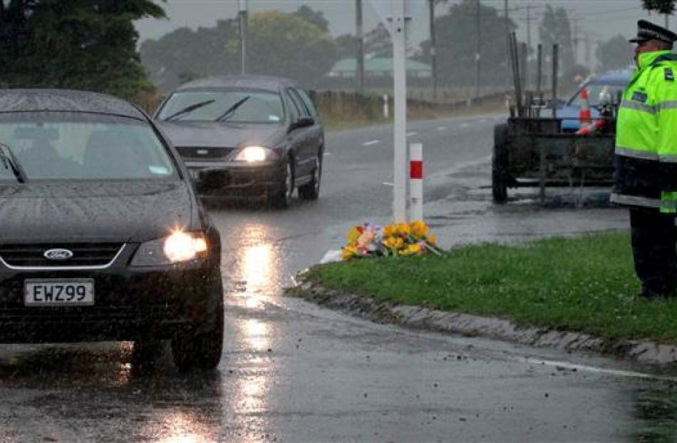 A guard of police officers stand to attention as two hearses carry away the bodies of victims...