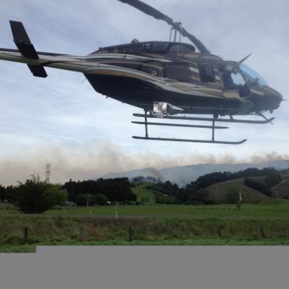 A helicopter works to put out a blaze near Outram this morning. Photo by Stephen Jaquiery.