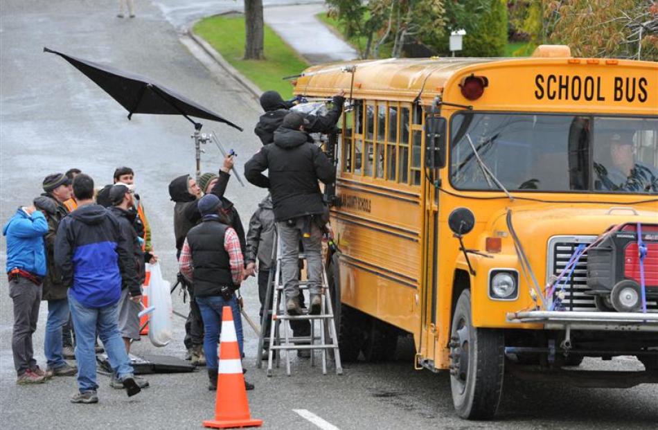 A Hollywood film crew shoots a scene from Pete's Dragon on a yellow school bus in Tapanui...