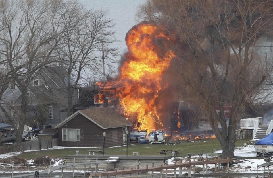 A house burns after a man set fire and then shot and killed a responding police officer and a...