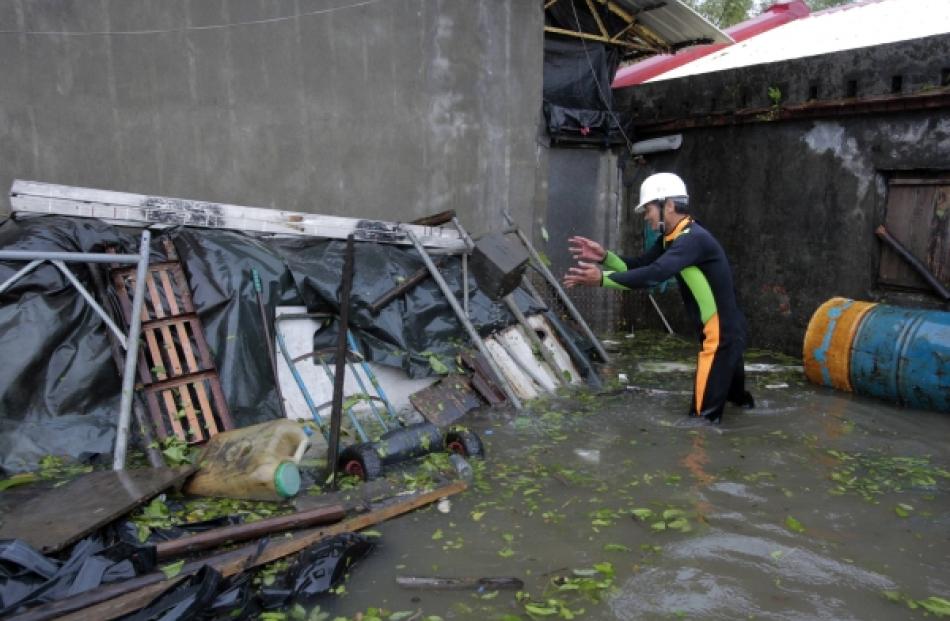 A man clears debris near his house flooded by Typhoon Saola in Wujie in Ilan County, Taiwan....