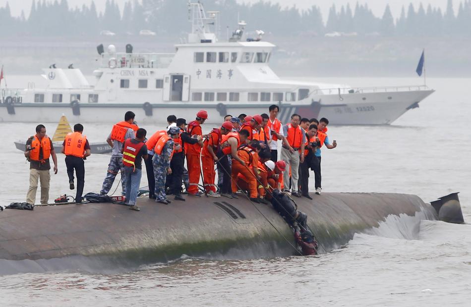 A man is pulled out alive by divers and rescuers. Photo by Reuters