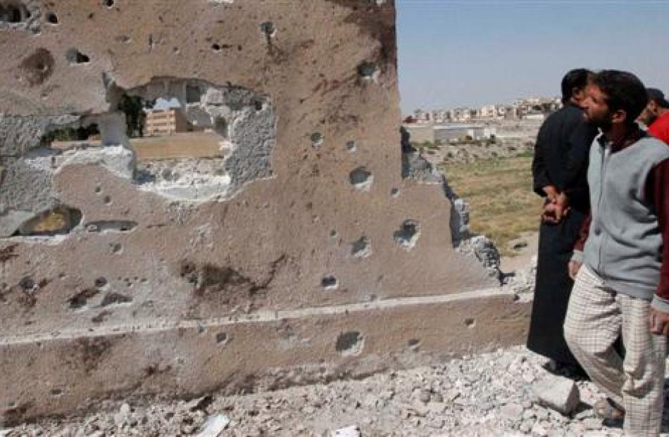 A man looks at one of the walls of the secondary school that activists say was hit by an air...