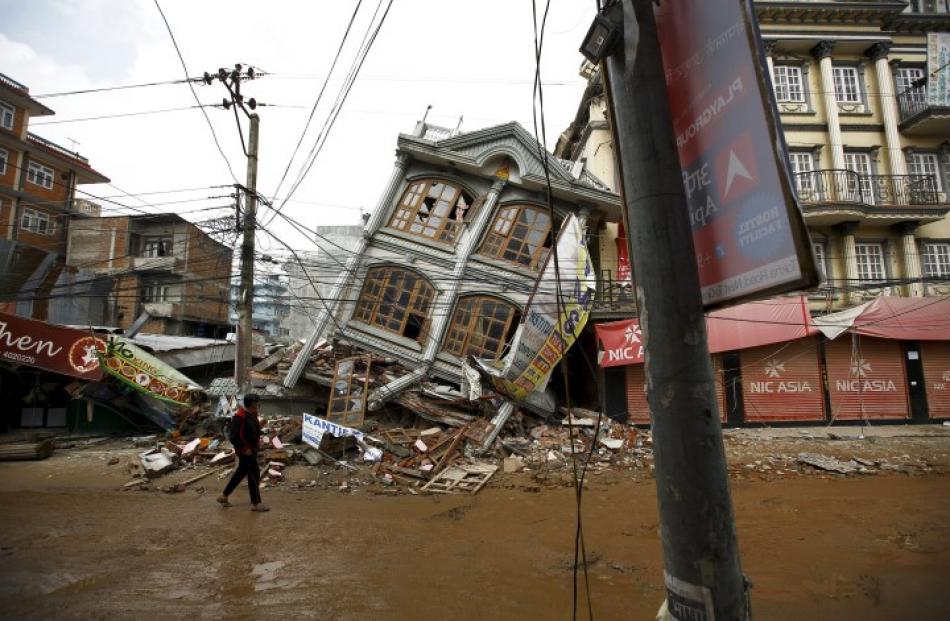 A man walks along the street near a collapsed house in Kathmandu. REUTERS/Navesh Chitrakar