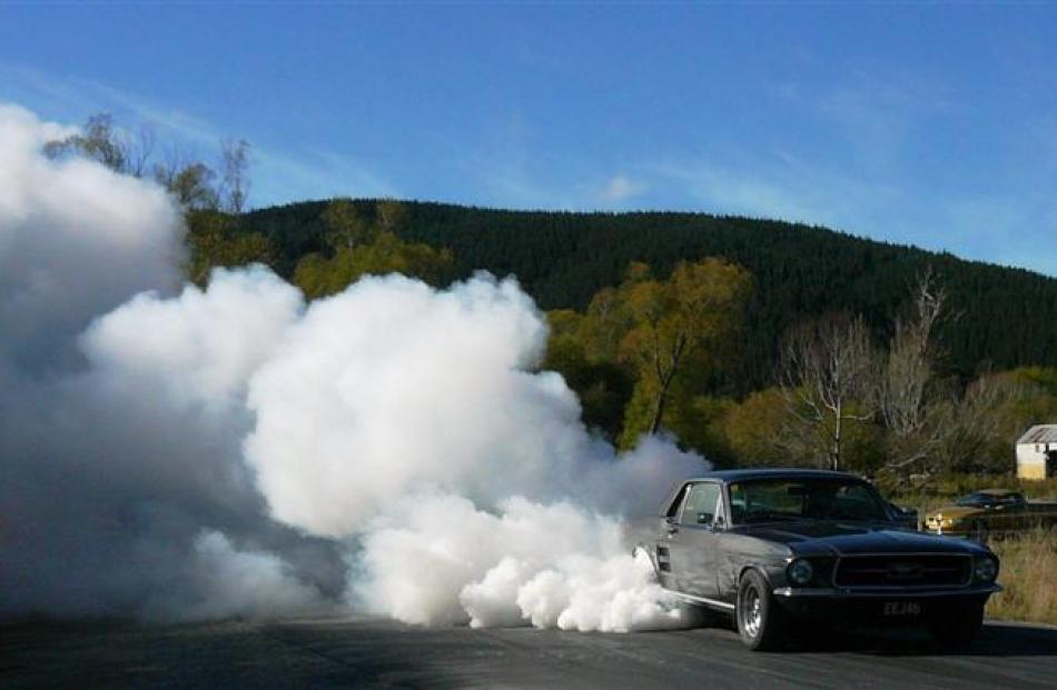 A Mustang creates a plume of smoke at the Lawrence quarter-mile sprints last year. Photo by Kim...