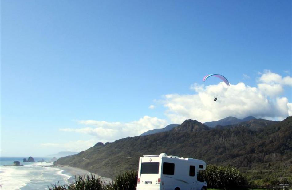 A parapenter catches the thermals by a coastal lookout just north of Greymouth.  The busy tourist...