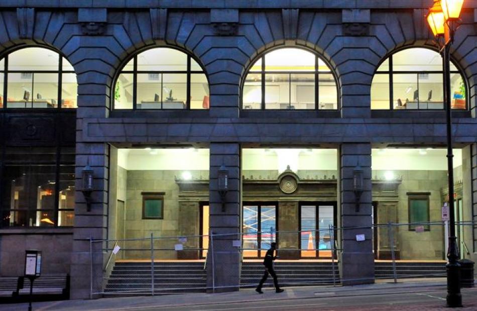 A pedestrian walks past Dunedin's former chief post office building last night. About 145 staff...