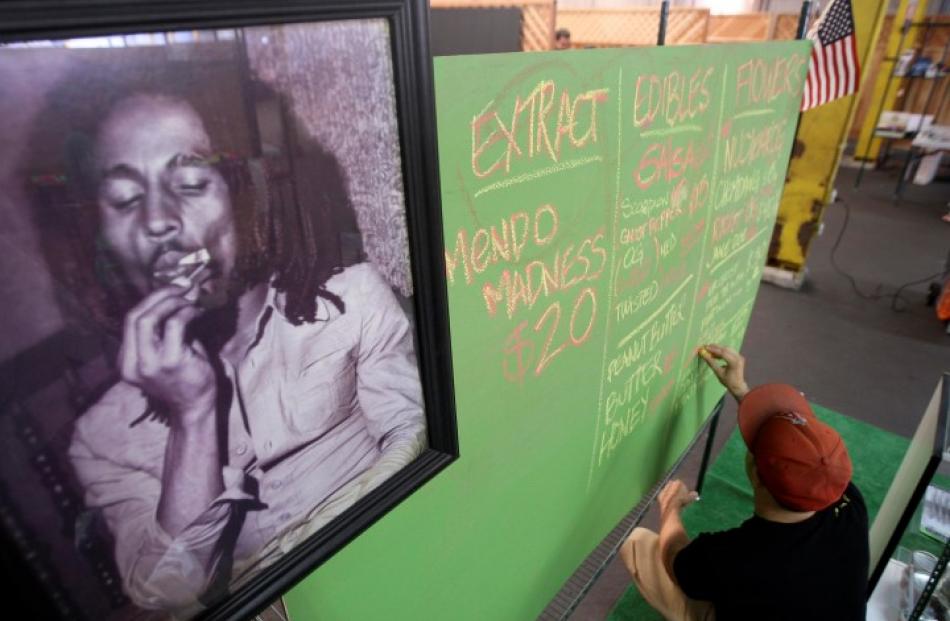 A portrait of Bob Marley hangs next to a menu of marijuana products at the medical marijuana...