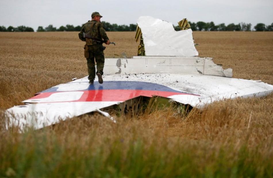 A pro-Russian separatist stands on part of the wreckage of the Malaysia Airlines Boeing 777 near...