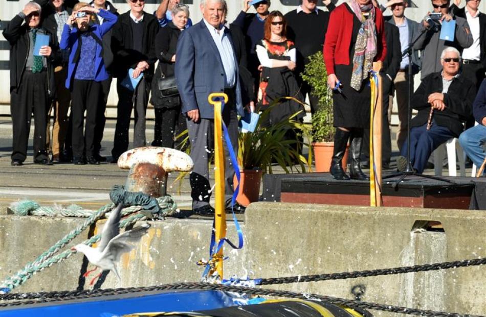 A seagull flees from a baptismal bottle of Champagne, watched by Port Otago's chairman Dave...