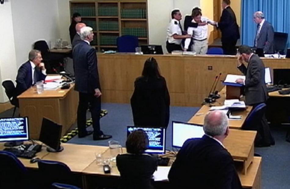 A still image shows a protester being restrained by security as Britain's former prime minister...