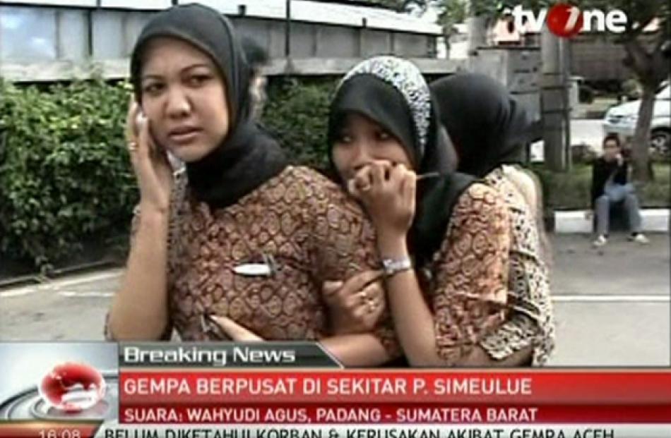 A still image taken from video shows a woman speaking on her mobile phone after an earthquake in...