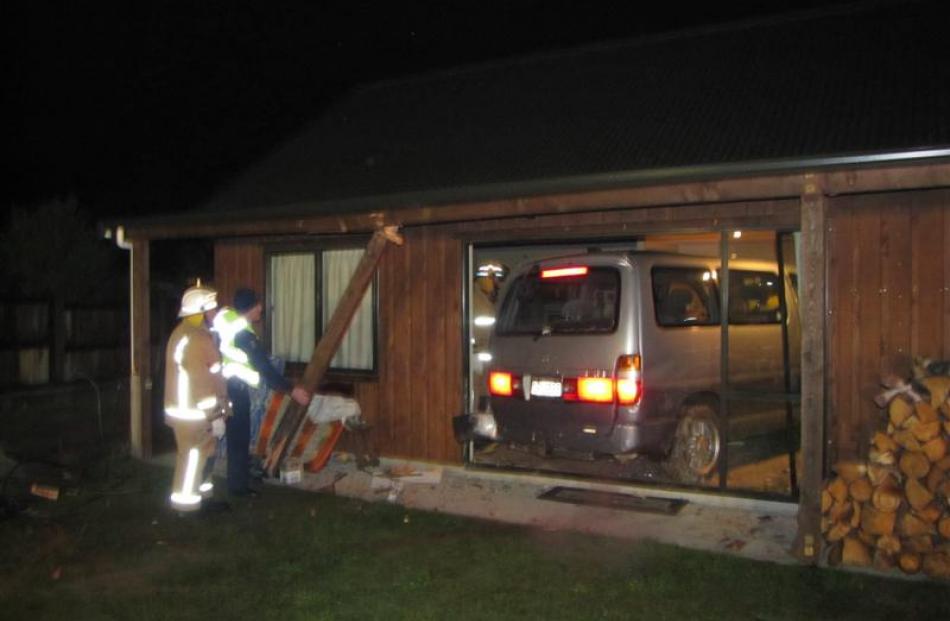 A Toyota Granvia people mover is reversed out of the lounge of a Lake Hawea house last night....