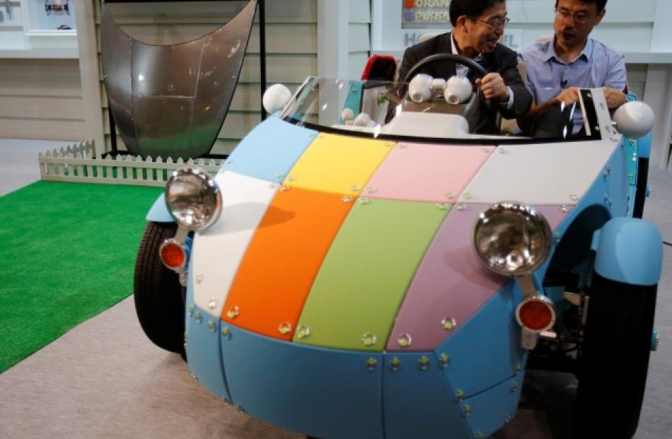 A Toyota staff member shows the Camatte57s to a member of the media at the International Toy Show...