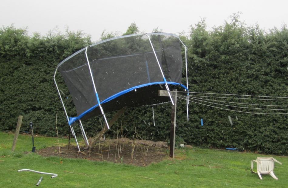 A trampoline rests on a clothesline post at a Millers Flat property after being blown there as a...