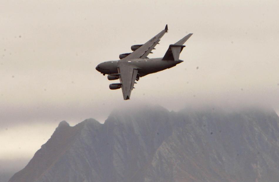 A US Globemaster aircraft turns to line up the Wanaka airport with Mt Gold near Hawea in the...