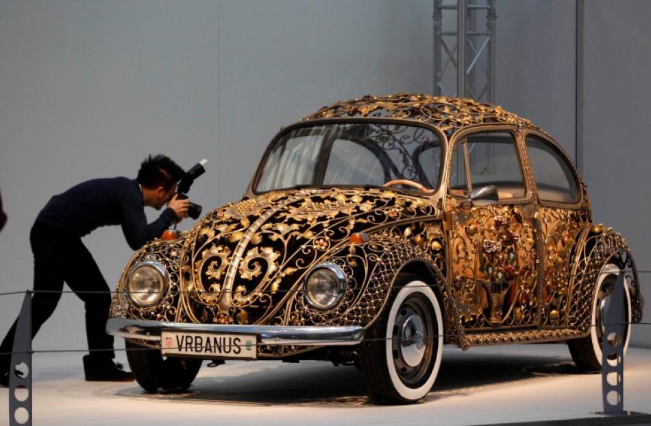 A visitor takes a picture at a modified Volkswagen VW Beetle before the show. REUTERS/Ina Fassbender