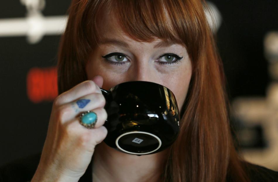 A woman drinks tea in a T2 shop in London. REUTERS/Stefan Wermuth