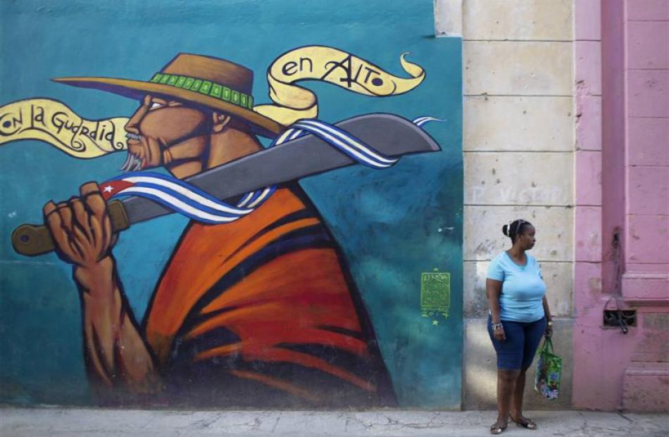 A woman stands on the street in downtown Havana.  From bus drivers to bartenders and ballet...
