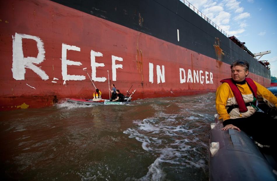 Activists paint the message 'Reef in Danger' on the side of coal ship Chou San in Gladstone,...