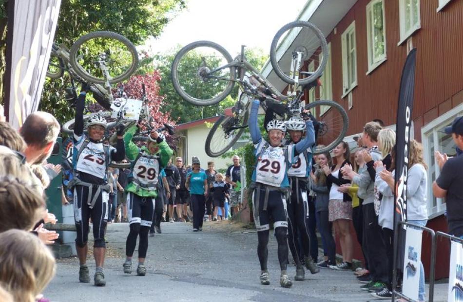 Adventure racingTeam Seagate raise their mountain bikes in triumph after winning the Godzone...