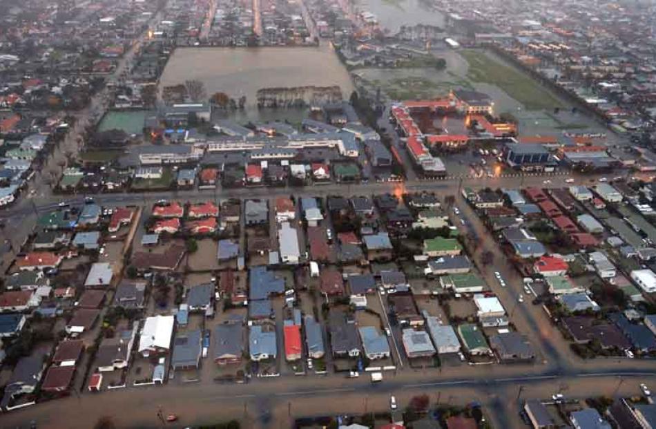 Aerial view of South Dunedin: Queen's High School (left) with a flooded Tonga Park behind and...