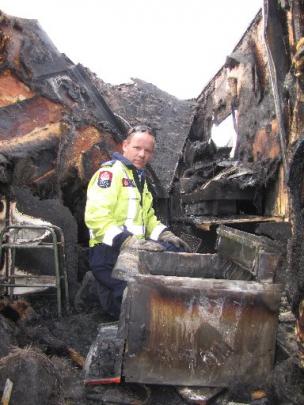 Alexandra Volunteer Fire Brigade Senior Station Officer Glen Gray inspects the burnt-out  pie...