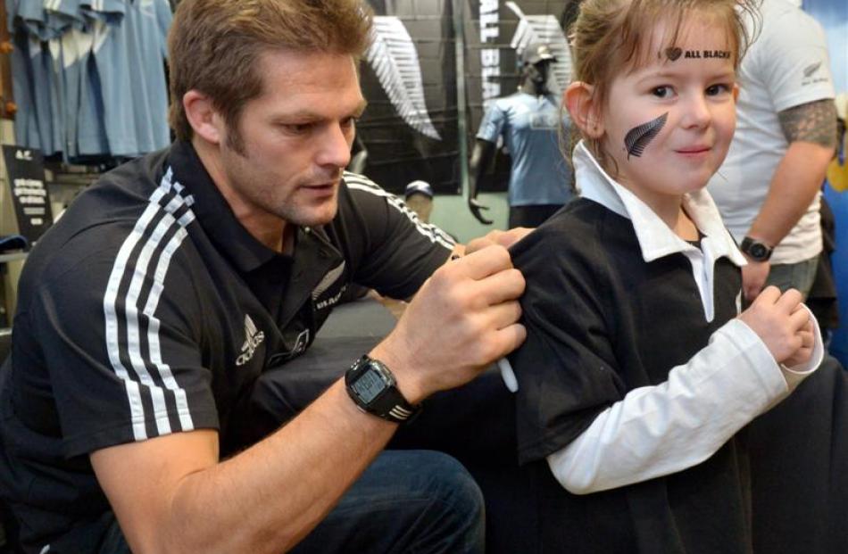 All Black captain Richie McCaw signs a jersey for Elizabeth Darling (6), of Dunedin, at Champions...