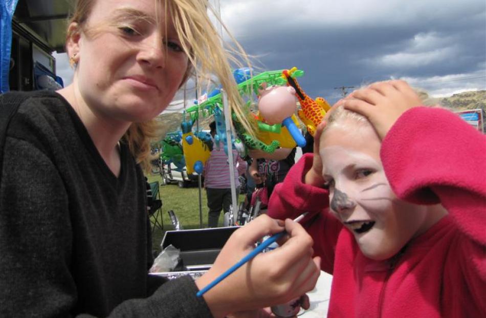 Amberrose Nicol (8), of Millers Flat, gets her face painted by Breana Horrell (14), of Te Anau,...