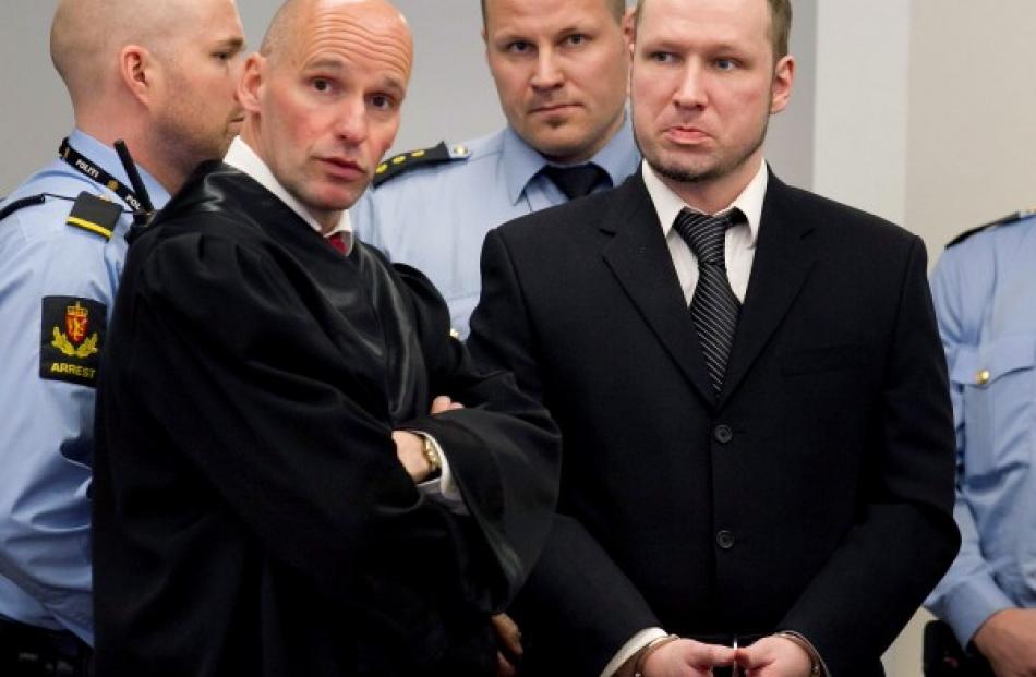 Anders Behring Breivik (R) is seen with his lawyer Geir Lippestad during the third day of...