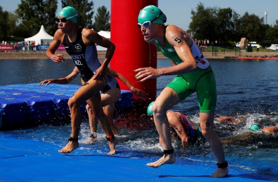 Andrea Hewitt of New Zealand (L) and Aileen Reid of Northern Ireland run out of the water during...