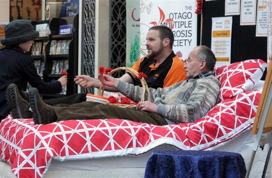 April Perkins McMillan (7) makes a donation to Otago Multiple Sclerosis field officer Don Benn ...