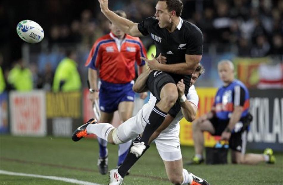 Israel Dagg passes the ball as he is tackled by France's Alexis Palisson. (AP Photo/Themba Hadebe)