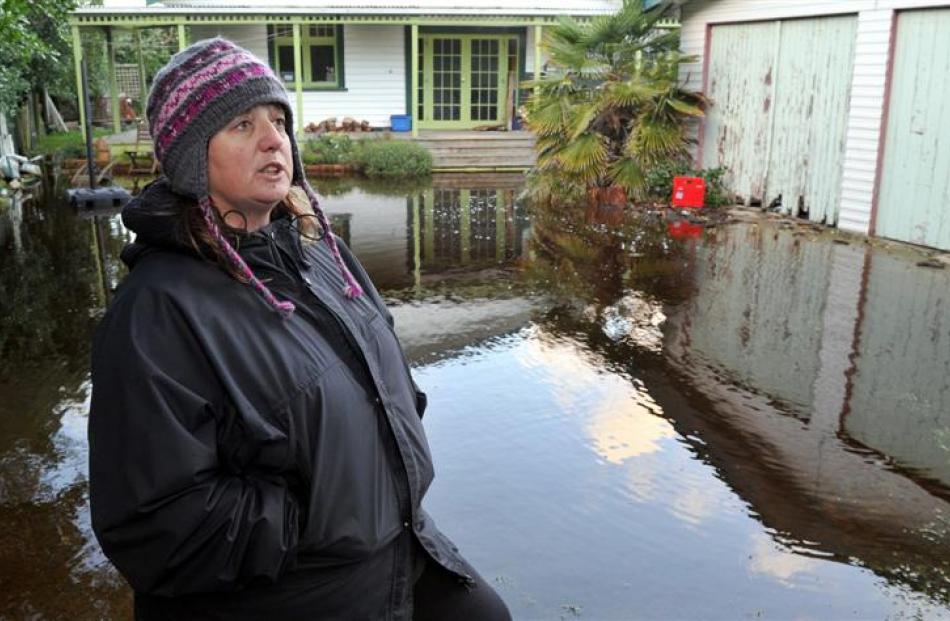 Aramoana League member Vicki Wilson stands next to one of about a dozen Aramoana properties which...
