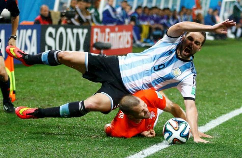 Argentina's Gonzalo Higuain (top) falls on Ron Vlaar of the Netherlands. REUTERS/Dominic Ebenbichler