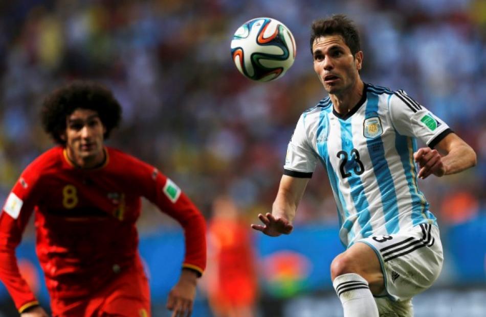 Argentina's Jose Basanta (R) tries to control the ball as Belgium's Marouane Fellaini approaches....